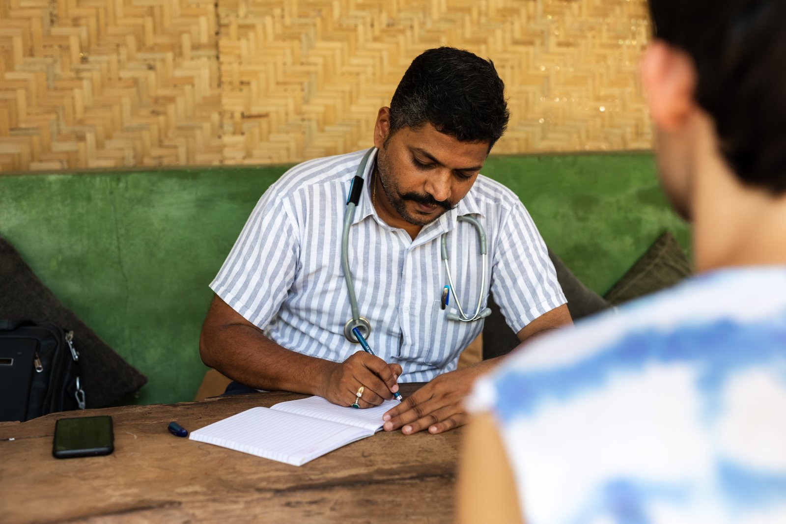 An Ayurvedic physician at SWAN writing up a consultation