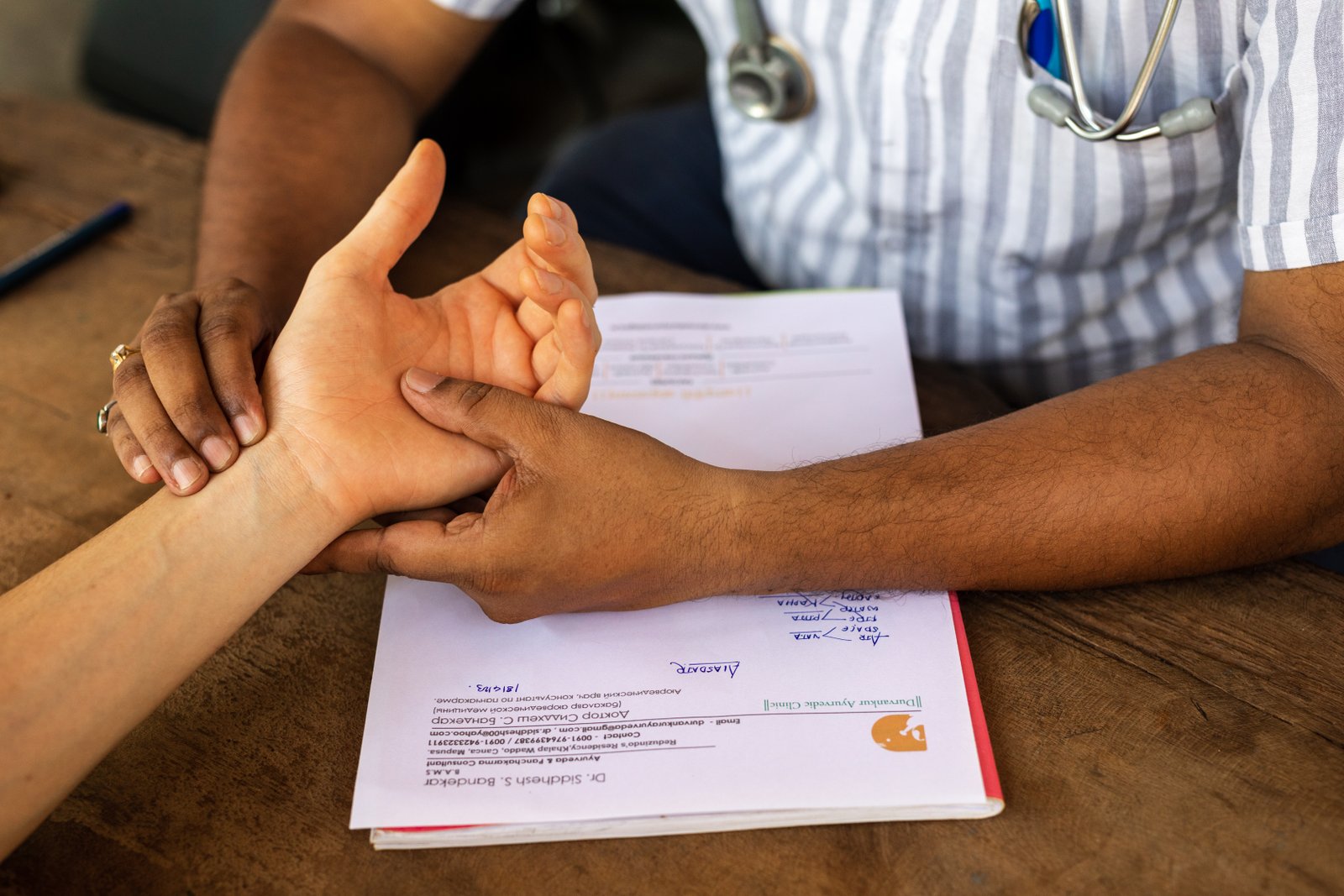 An Ayurvedic doctor taking a guest's pulse during consultation at SWAN